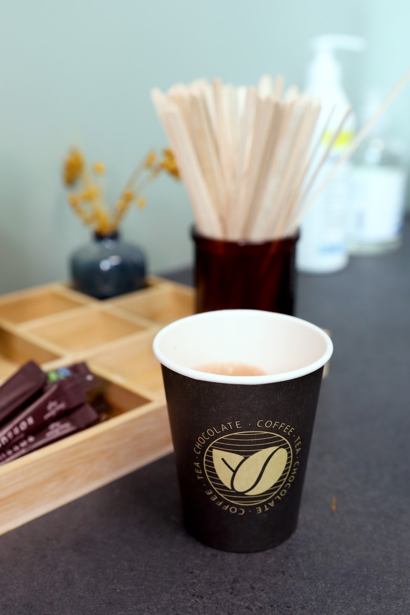 En kop varm kakao står og køler af fra en kaffeautomat i vente området hos Benefit Viborg