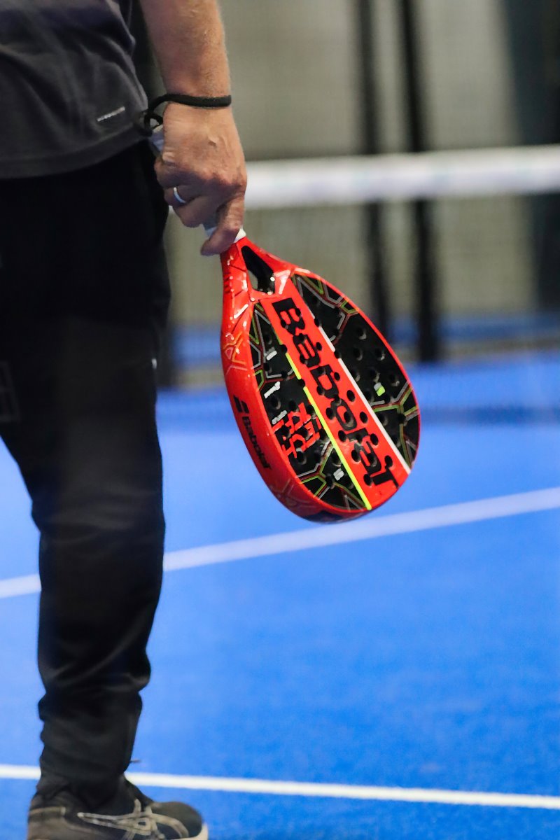 Closeup af et padel bat med røde og sorte farver fra Viborg padel